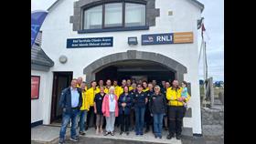 Volunteers and Crew of the Aran islands RNLI standing in front of the station and shop
