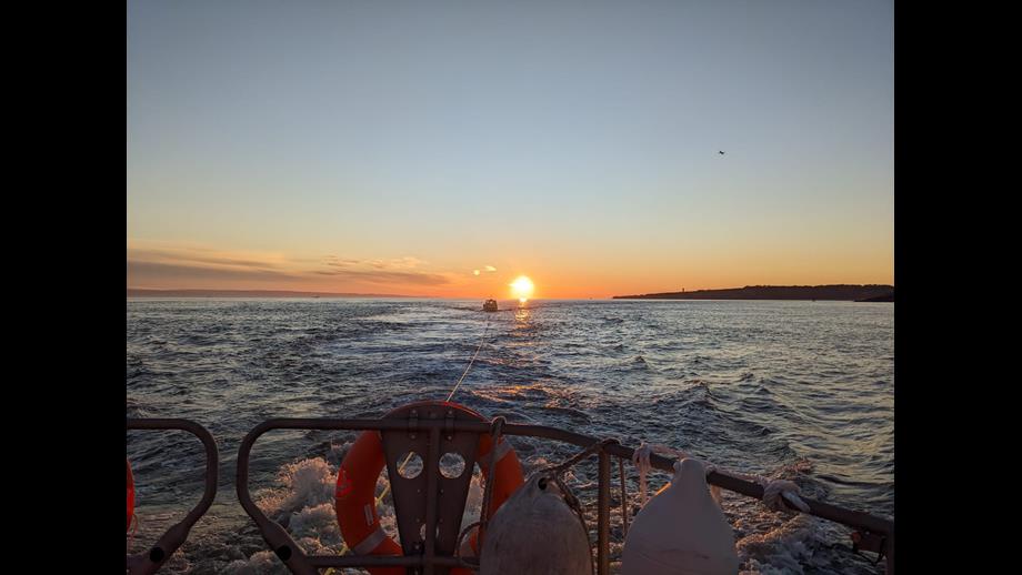 The photo shows the fishing boat being towed to safety by Barry Dock RNLI as the sunsets