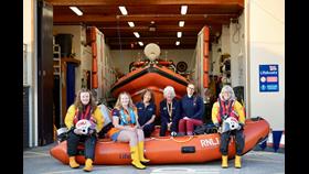 Female crew members sat upon an inshore rescue boat.