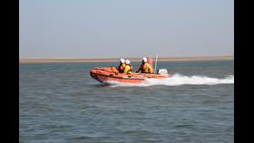 Wells RNLI D class lifeboat on cut off by tide rescue with crew of three on open water
