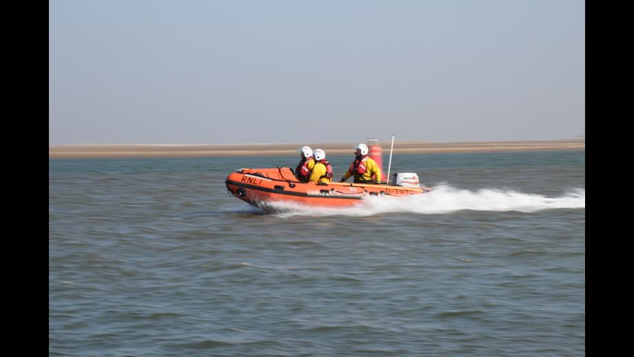 Wells RNLI D class lifeboat on cut off by tide rescue with crew of three on open water
