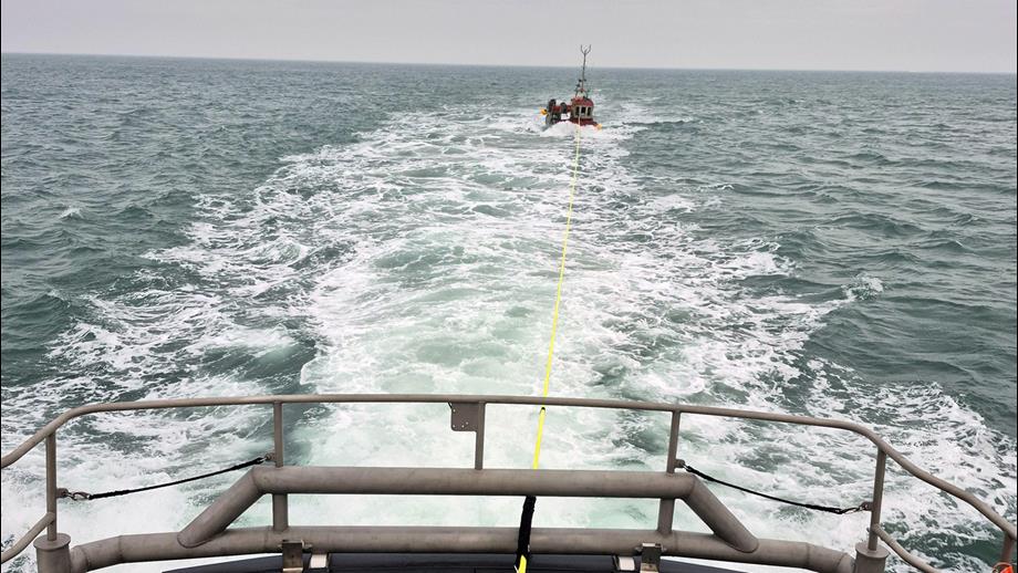 tow line from bow of the lifeboat to small fishing boat in the distance