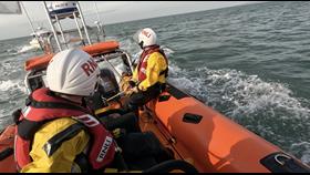 Lifeboat crew in Atlantic 85 looking back towards tow of yacht.