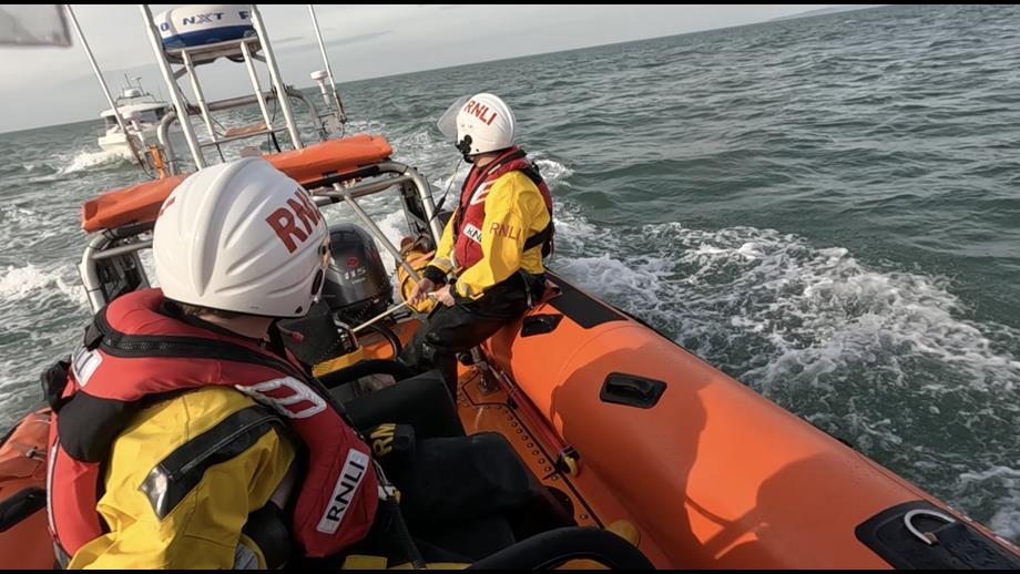 Lifeboat crew in Atlantic 85 looking back towards tow of yacht.