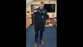 Resilience Coxswain/Mechanic Thomas Davis holding up a Aran Islands crew tshirt
