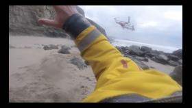 Helicopter taking off from small beach area.