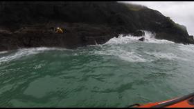 Taken on Helmet Cam - Photo of crewman on rocks with casualty at Porth