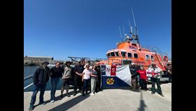 Crew of Le Biche &amp; Aran Islands RNLI holding up the RNLI flag and SNSM flag in front of the Severn Lifeboat
