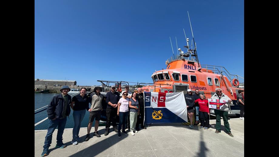 Crew of Le Biche &amp; Aran Islands RNLI holding up the RNLI flag and SNSM flag in front of the Severn Lifeboat