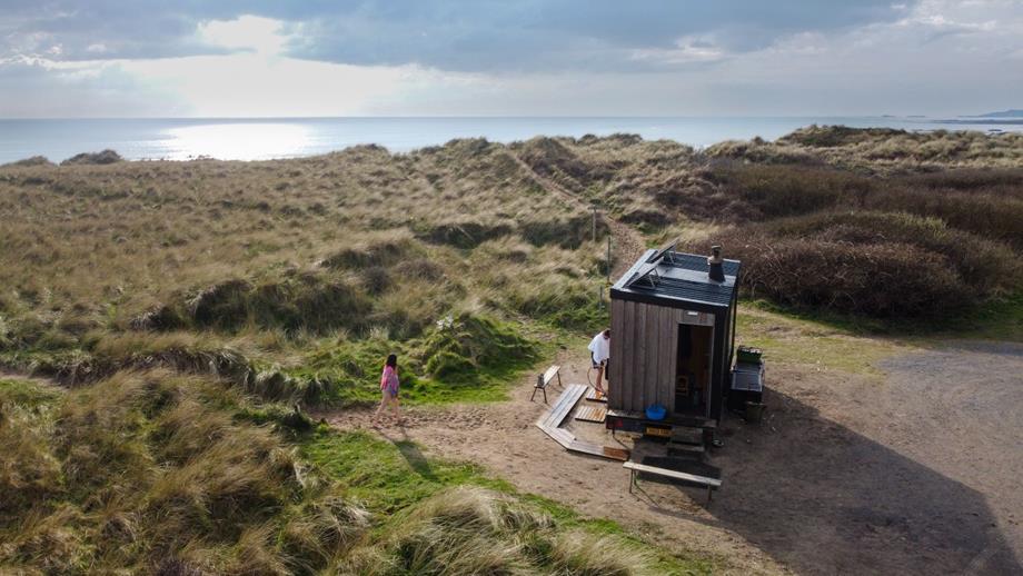 An outdoor sauna on the sand dunes, looking out towards the sea