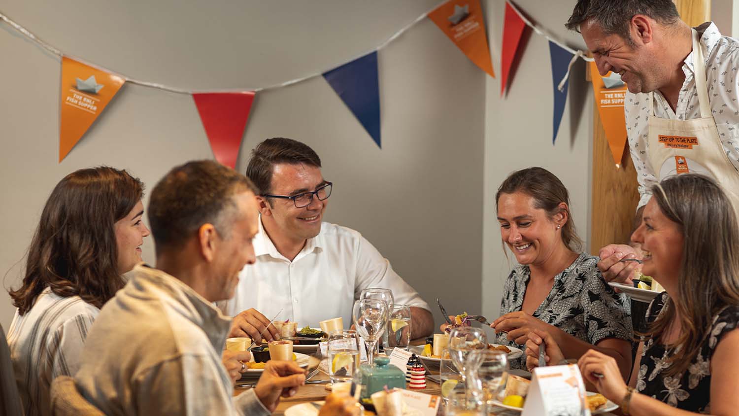 Group of people around the dining table enjoying a meal together