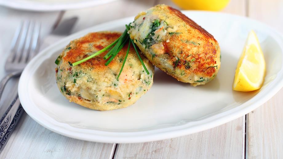 Two fishcakes on a plate with a lemon wedge. Photo: Shutterstock/Magdanatka