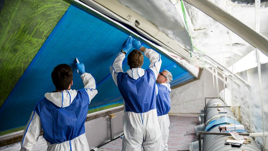 Boatbuilders working on the hull of a Shannon class lifeboat at the All-weather Lifeboat Centre