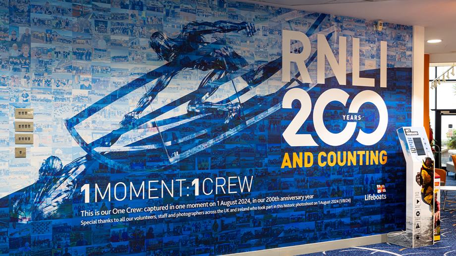 A montage of hundreds of photos of RNLI communities taken at the same moment in time - 18:24 - on 1 August 2024. Over the photos is a transparent image of the RNLI Memorial sculpture. 