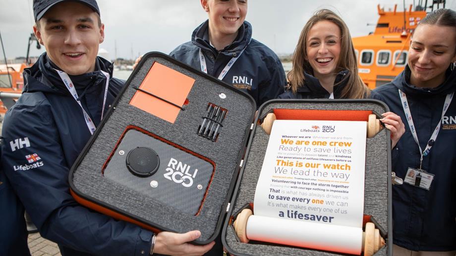 RNLI Face to Face team holding the RNLI 200 scroll and case
