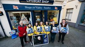 Volunteers outside RNLI Ramsey Shop holding the new Isle of Man post Office stamps for RNLI 200 Anniversary