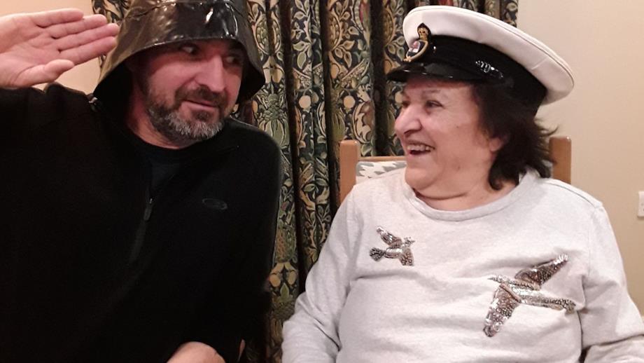 Colour photograph of care home resident and session facilitator trying on RNLI kit