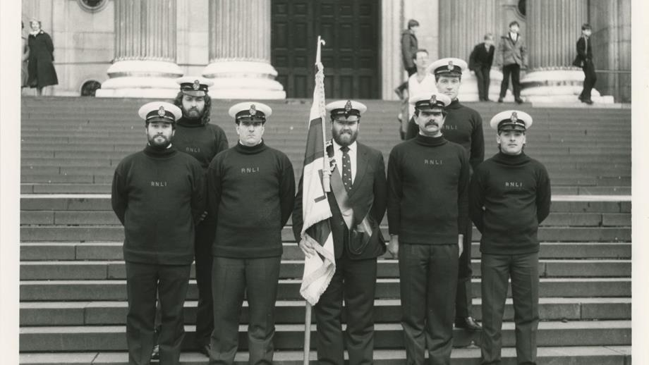 Black and white image of crew including flagbearer outside St Paul's Cathedral