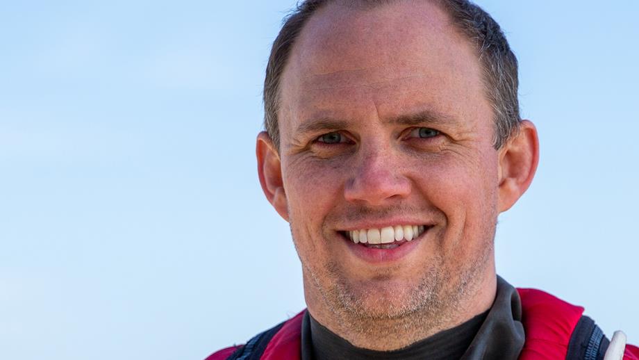 Male crew member looks to camera and is smiling