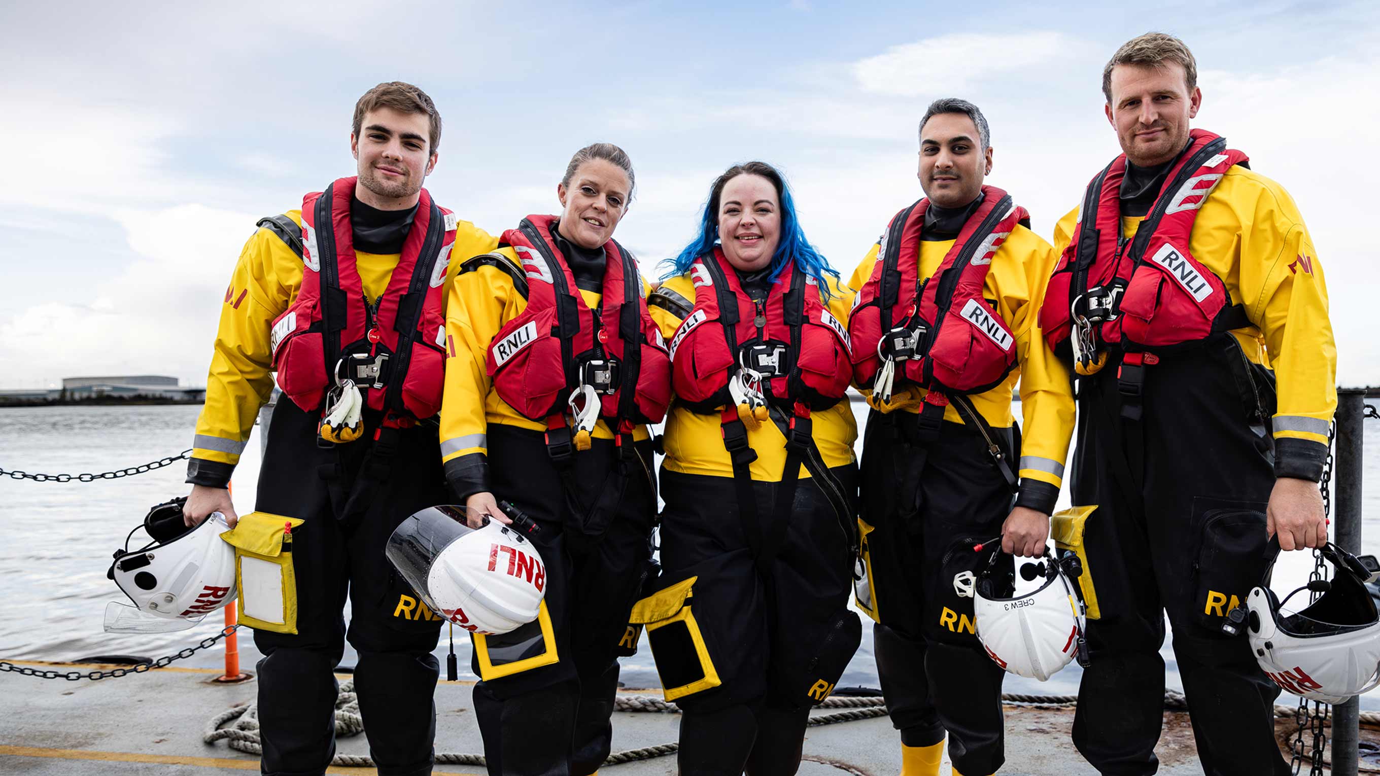 Five lifeboat crew members from Gravesend Lifeboat wearing inshore lifeboat kit pose for a group photo