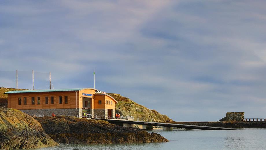 A view across rocks towards Porthdinllaen Lifeboat Station