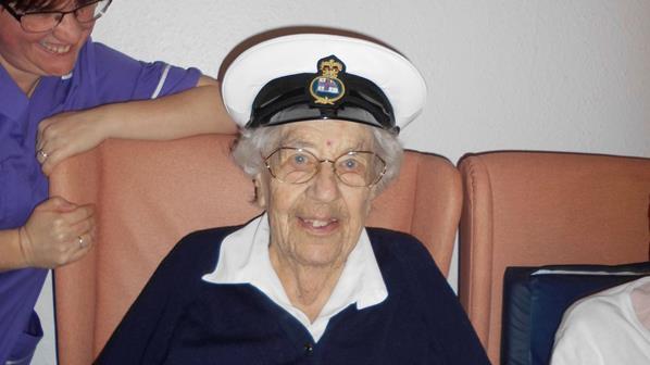 Colour photograph of a care home resident trying on RNLI cap