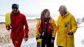 Group of walkers including RNLI crew members, lifeguards, fundrasiers