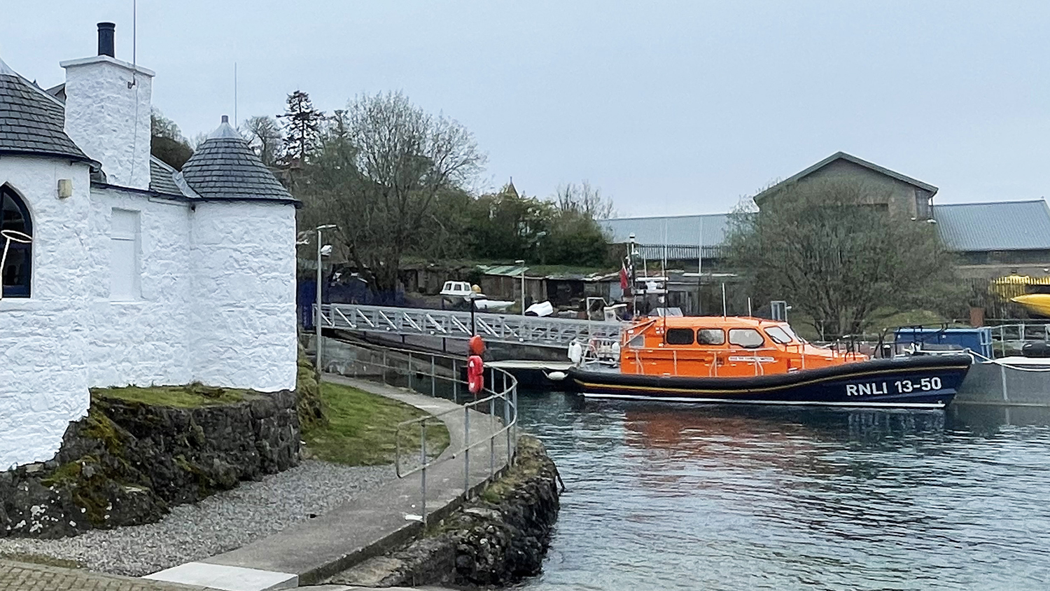 Lifeboat anchored near white building.