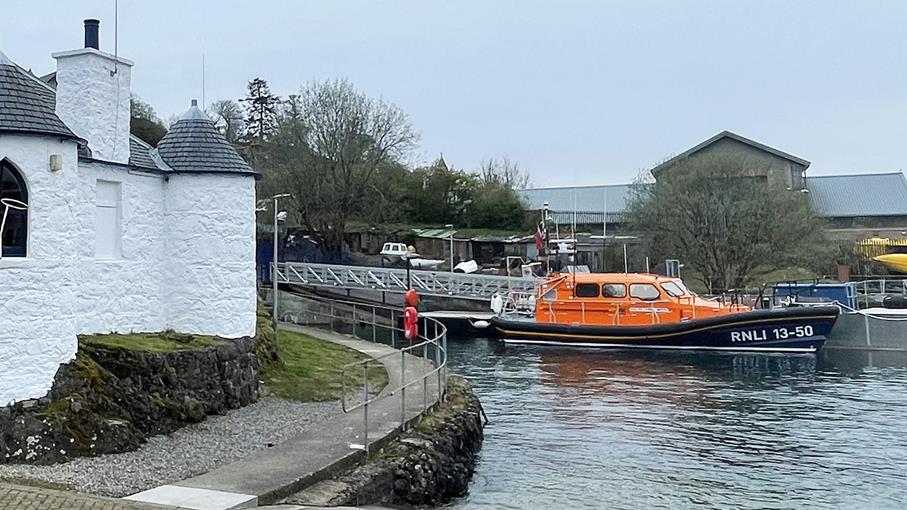 Lifeboat anchored near white building.
