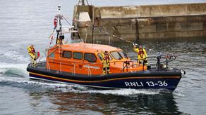 RNLI Seahouses lifeboat crew waving from their Shannon class lifeboat