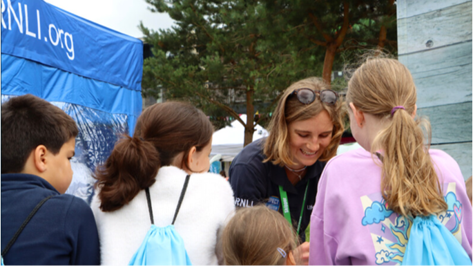 Photo of an RNLI Water Safety officer speaking to a group of children