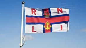 RNLI flag flying against a bright blue sky