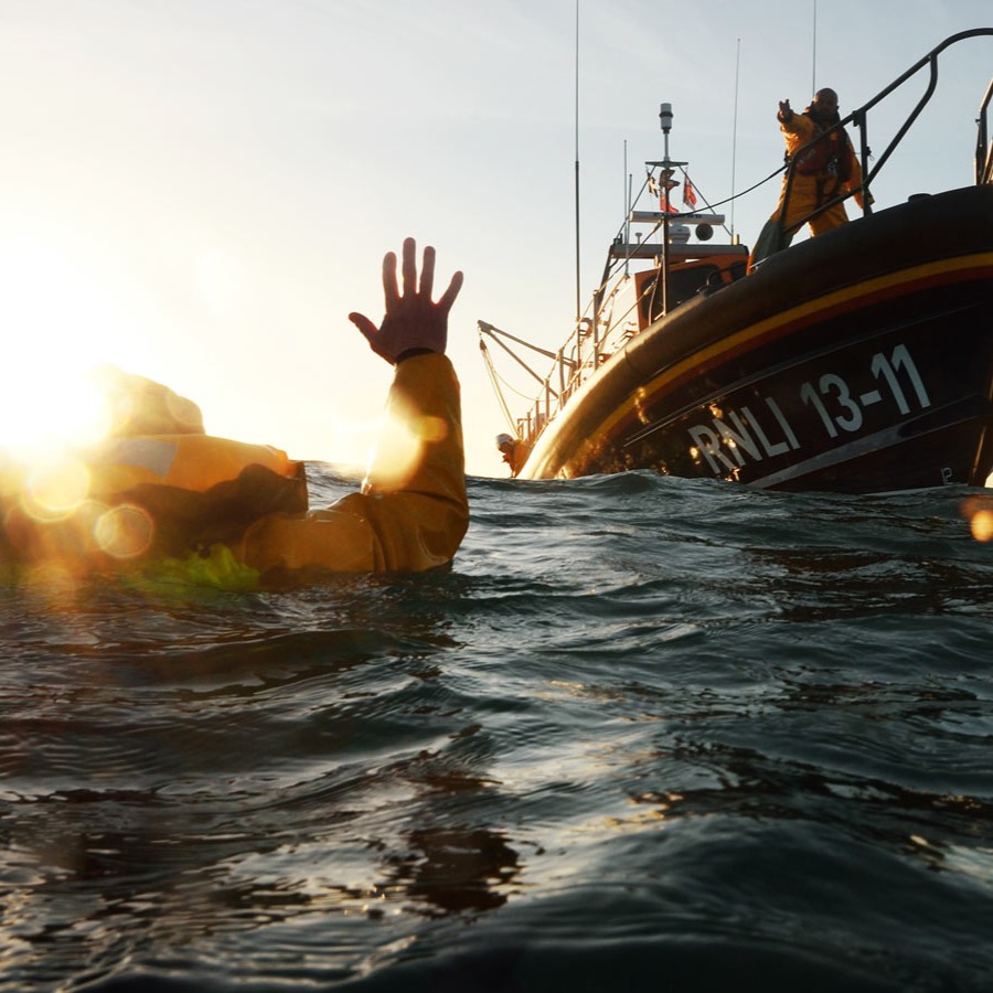 A person in the water signalling to the lifeboat.