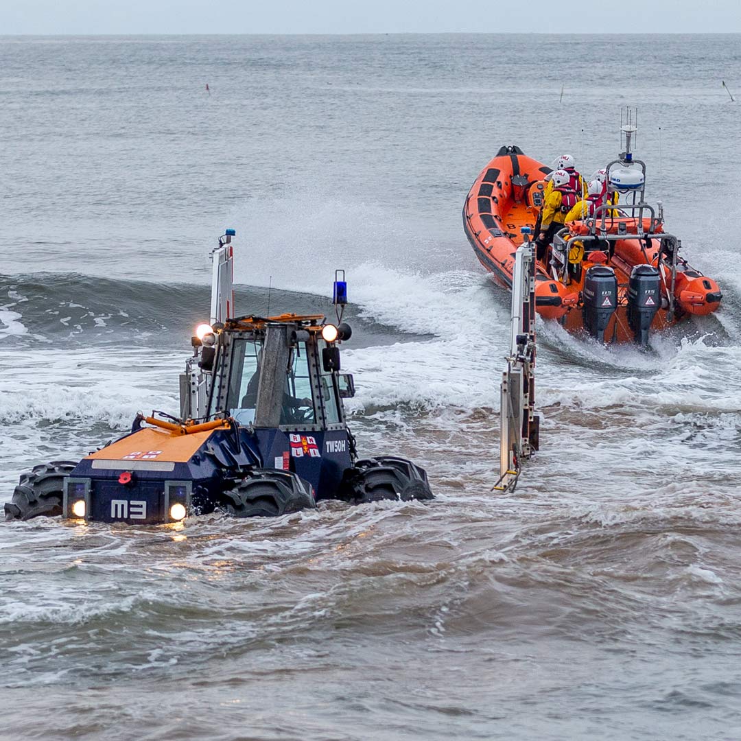 D class inshore lifeboat launches from a tractor into heavy surf