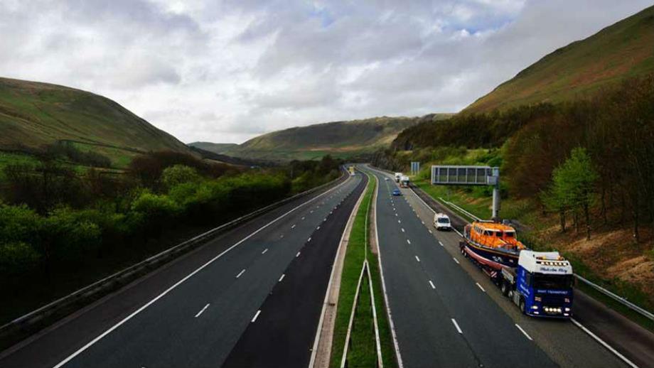 An RNLI lifeboat being transported via motorway