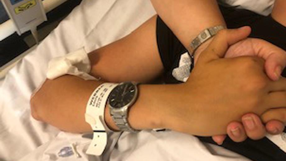 Emma holds Louis's hand in the hospital