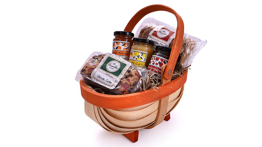 A wicker basket filled with preserves, biscuits and fruit cake 