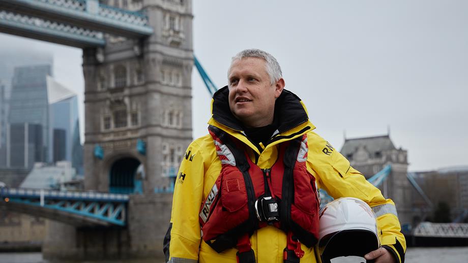 Tower RNLI Commander Neil Ceconi stands in front of Tower Bridge