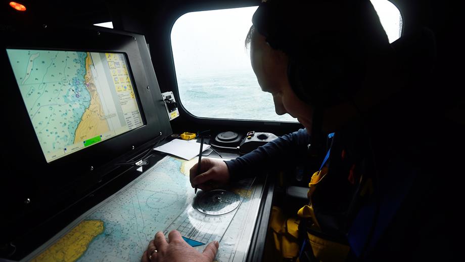 A lifeboat crew member checking his charts 