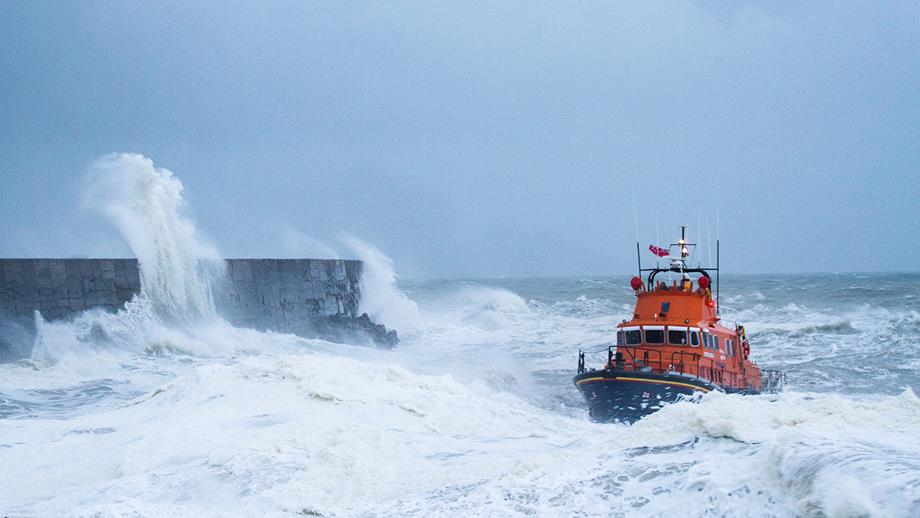 An RNLI lifeboat conducts a search in rough seas