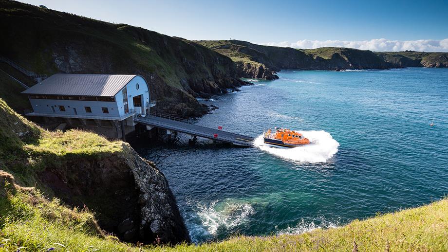 The Lizard Lifeboat Station on a sunny day, their Tamar class lifeboat in the water after launching down the slipway