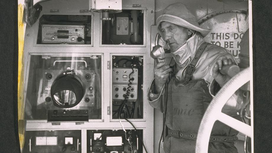 A photograph from the 1950s showing Lifeboat Mechanic Hodder from Plymouth RNLI using communication equipment aboard the lifeboat