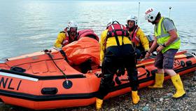 The Llandudno crew return the kayakers to shore, with the lifeboat on a pebbled beach