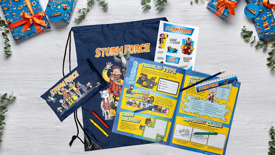 A Storm Force membership pack, showing a children’s magazine, stickers and a pencil case with a navy-blue drawstring bag