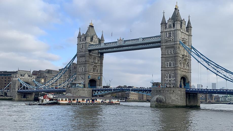 The old Tower Lifeboat Station passes under Tower Bridge, as it’s floated to its new home