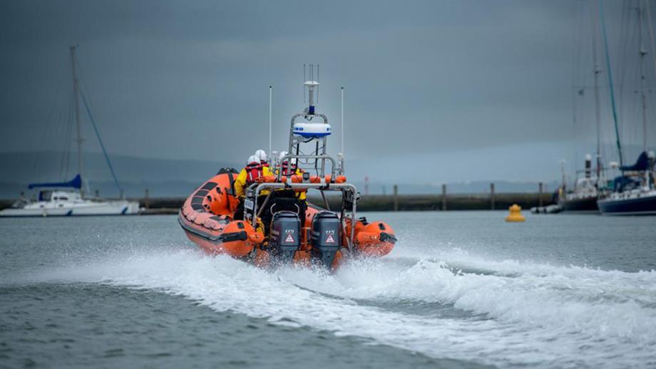 A B class lifeboat heading out of the harbour on a grey, stormy day