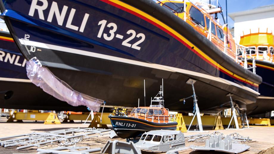 A completed model Shannon class lifeboat in front of a real RNLI Shannon class lifeboat 