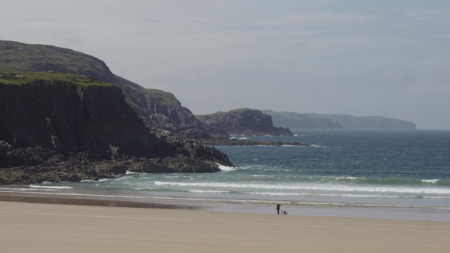 Small waves roll into the rock-framed Farr Bay in the Scottish Highlands