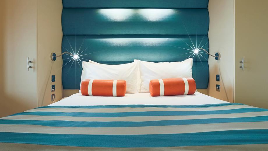 A double bed at the RNLI College, in a blue and orange colour theme