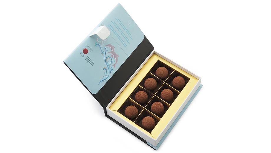 Eight round chocolate truffles, presented in a blue and gold box 